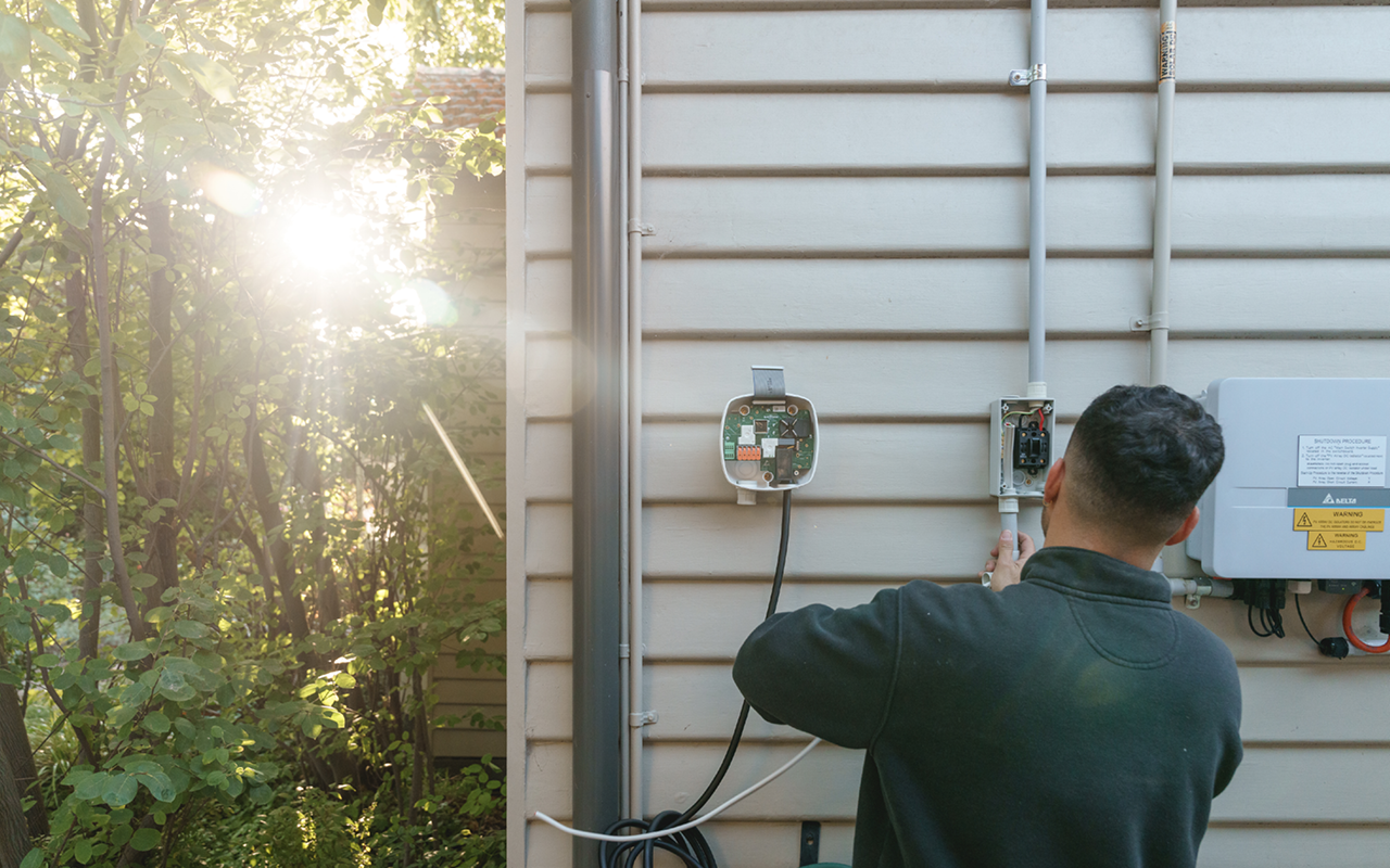 A EV charger being installed on a wall